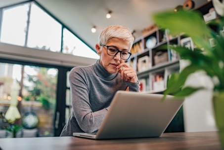 a woman looking at her laptop